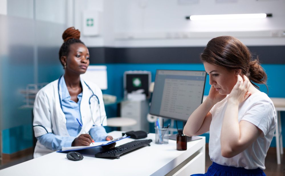 General practitioner doctor consulting patient with sore, hurt, aching painful neck nape symptoms. Healthcare specialist medical appointment check-up in modern clinic office